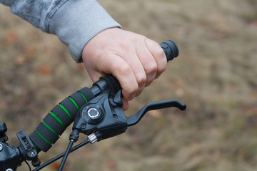 the male strong hand holds a bicycle wheel