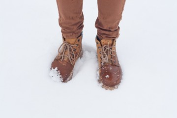 feet in boots on snow. waterproof footwear.