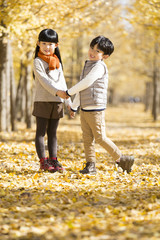 Fototapeta premium Two children playing in autumn woods
