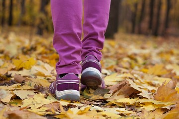 to walk on leaves in sneakers. convenient sports shoes on a foot. stylish fashionable footwear