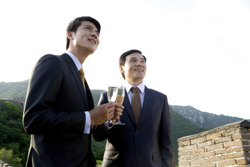 Businessmen having champagne on the Great Wall