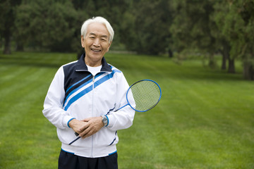 Senior Man Holding Badminton Racket in a Park
