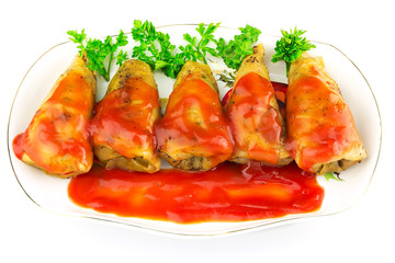 Cabbage roll with tomato sauce and parsley in plate, isolated on white background