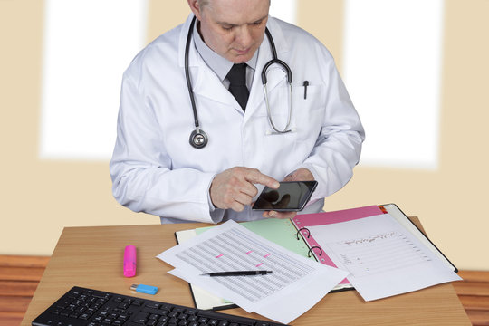 Doctor with stethoscope around his neck using his mobile phone
