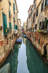 Picturesque view of Gondolas on lateral narrow Canal on a foggy day, Venice, Italy.