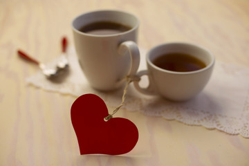 Valentines day couple with red paper heart, sugar and spoon on wooden table. Paper heart shape symbol for Valentines day. 