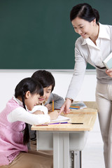 Smiling teacher teaching schoolchildren 