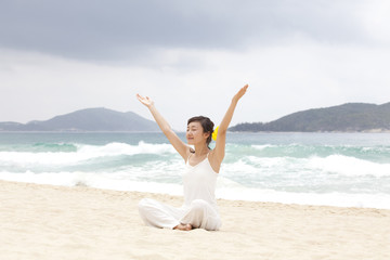 Fototapeta na wymiar A woman practicing yoga at the beach