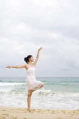 Fototapeta na wymiar A woman dancing at the beach