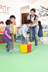 Cheerful kindergarten children playing games with teacher