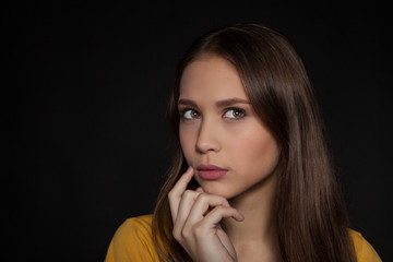 Contemplative thinking woman student at a black background - Stock Image