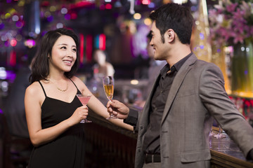 Young woman talking with young man in bar