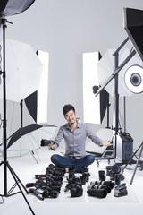 Photographer in studio with many cameras on the ground