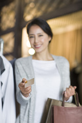Mature woman with credit card in clothing store