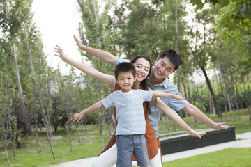 Obraz premium Portrait of happy young family with arms outstretched