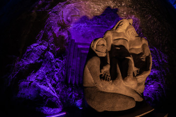 Jesus Stone sculpture front of purple light in the underground salt cathedral Zipaquira