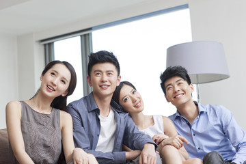 Fototapeta premium Happy young friends sitting on the sofa