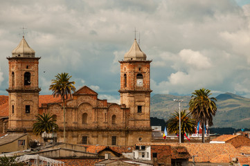 Old colonial stone church with roofs and palm tree near Bogota