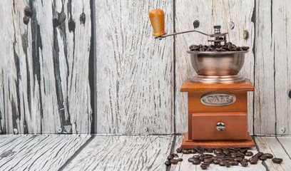 Roasted coffee bean with coffee mill over wooden background 