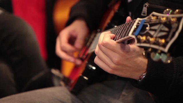Professional guitarist playing electric guitar close up process 