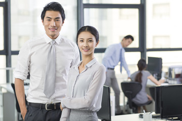 Obraz premium Portrait of young businessman and businesswoman in office