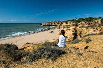 Fototapeta na wymiar Woman at Praia de Sao Rafael, Algarve, Portugal