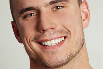 Portrait of young smiling young man close up