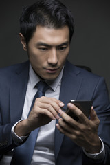 Confident businessman using smart phone