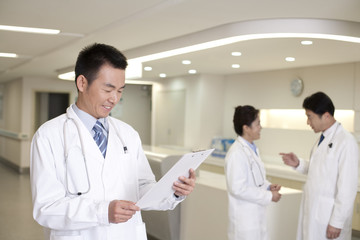 Confident doctor looking at paperwork