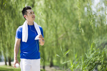 Fototapeta premium Young man with towel and water after jogging 
