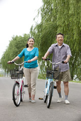 Senior couple cycling in park