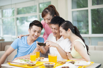 Young adults photographing foods in restaurant