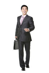 Obraz na płótnie Canvas Businessman walking with brief case in hand