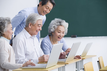 Fototapeta premium Senior adults having computer class at school