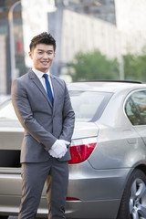 Portrait of chauffeur standing next to the car