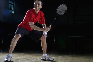 Young Man Preparing To Return A Shot During A Game Of Badminton