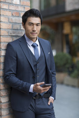 Confident businessman holding a smart phone