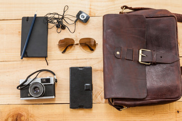 The image shows a retro or hipster bag for man or woman with stuff such as glasses , vintage...