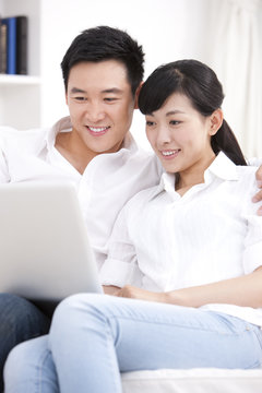 Young couple using laptop in sofa