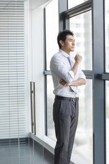 Young businessman looking through window