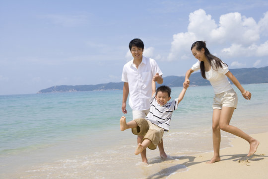Young family playing on the beach