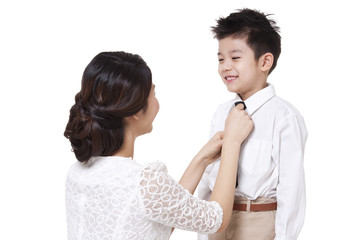 Naklejka premium Mother tying necktie for son