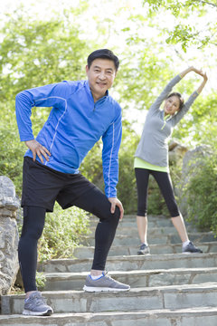 Happy mature couple exercising in park