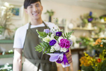 Fototapeta premium Male florist holding flower bouquet