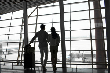 Fototapeta na wymiar Young couple at the airport looking at view