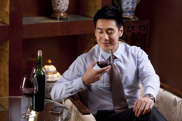 Young businessman enjoying wine in hotel