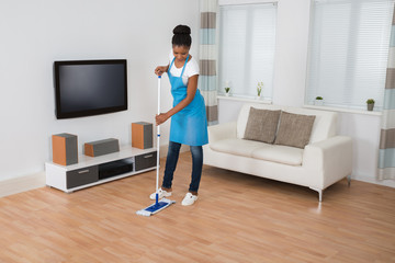 Woman Cleaning Floor In Living Room
