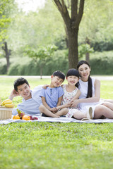 Happy young family having picnic on grass