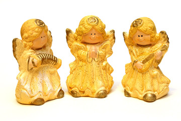 three ceramic figurines of angels yellow on a white background