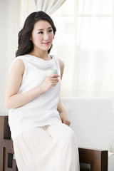 Happy young woman drinking tea